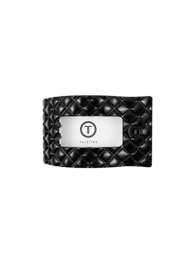 Black quilted rectangle hair clip on white background, front.