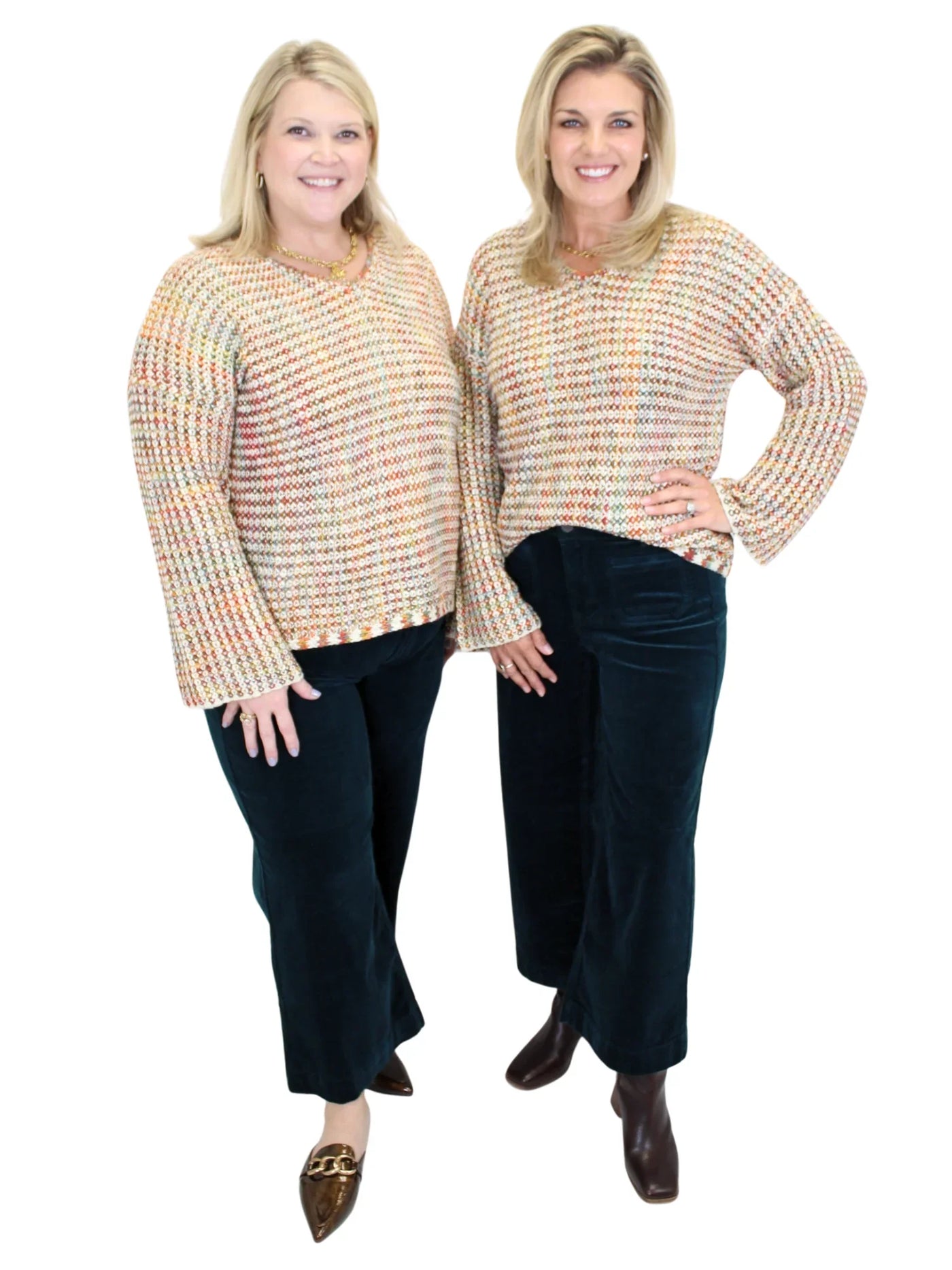 Two women wearing a multicolor sweater and dark teal corduroy pants on white background, front