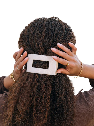 Beige flat medium rectangle hair clip in model's hair.