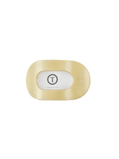 Packaged small yellow round hair clip on white background, front.