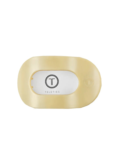 Packaged yellow large round hair clip on white background, front.