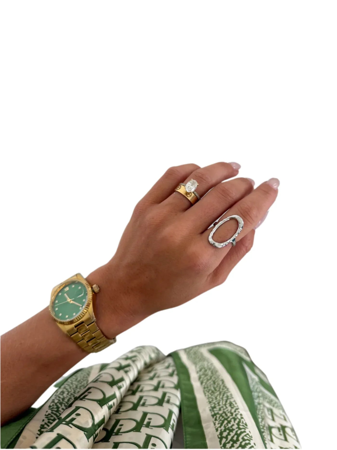 Hand wearing open silver open ring on white background.