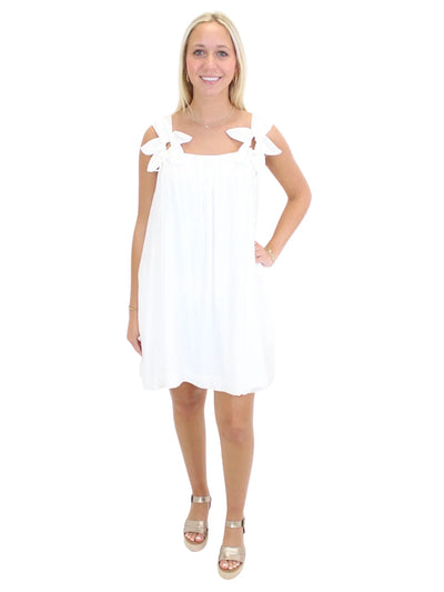White dress with flower straps on model, front.