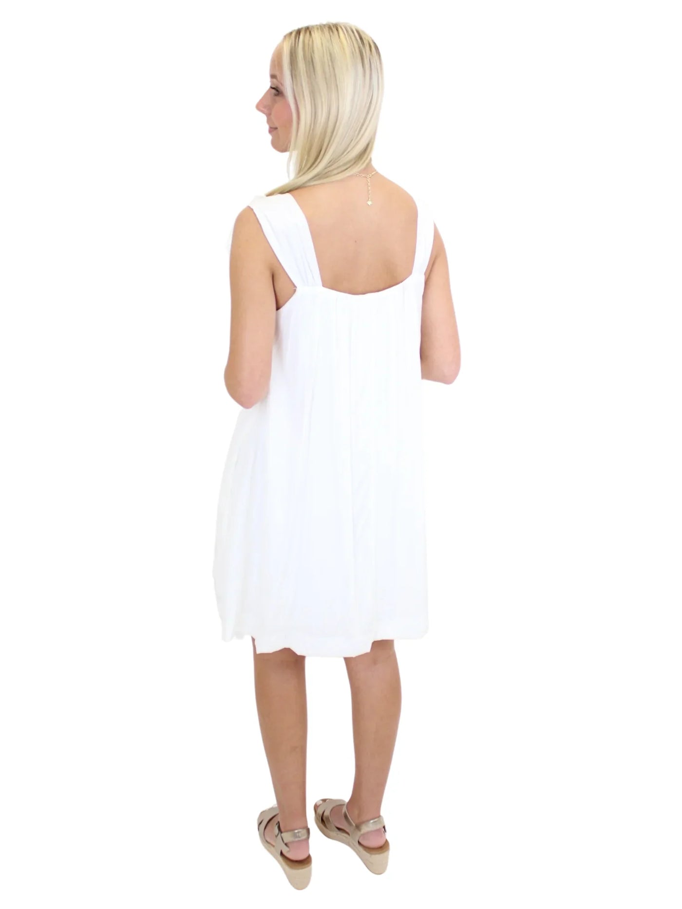 White dress with flower straps on model, back.