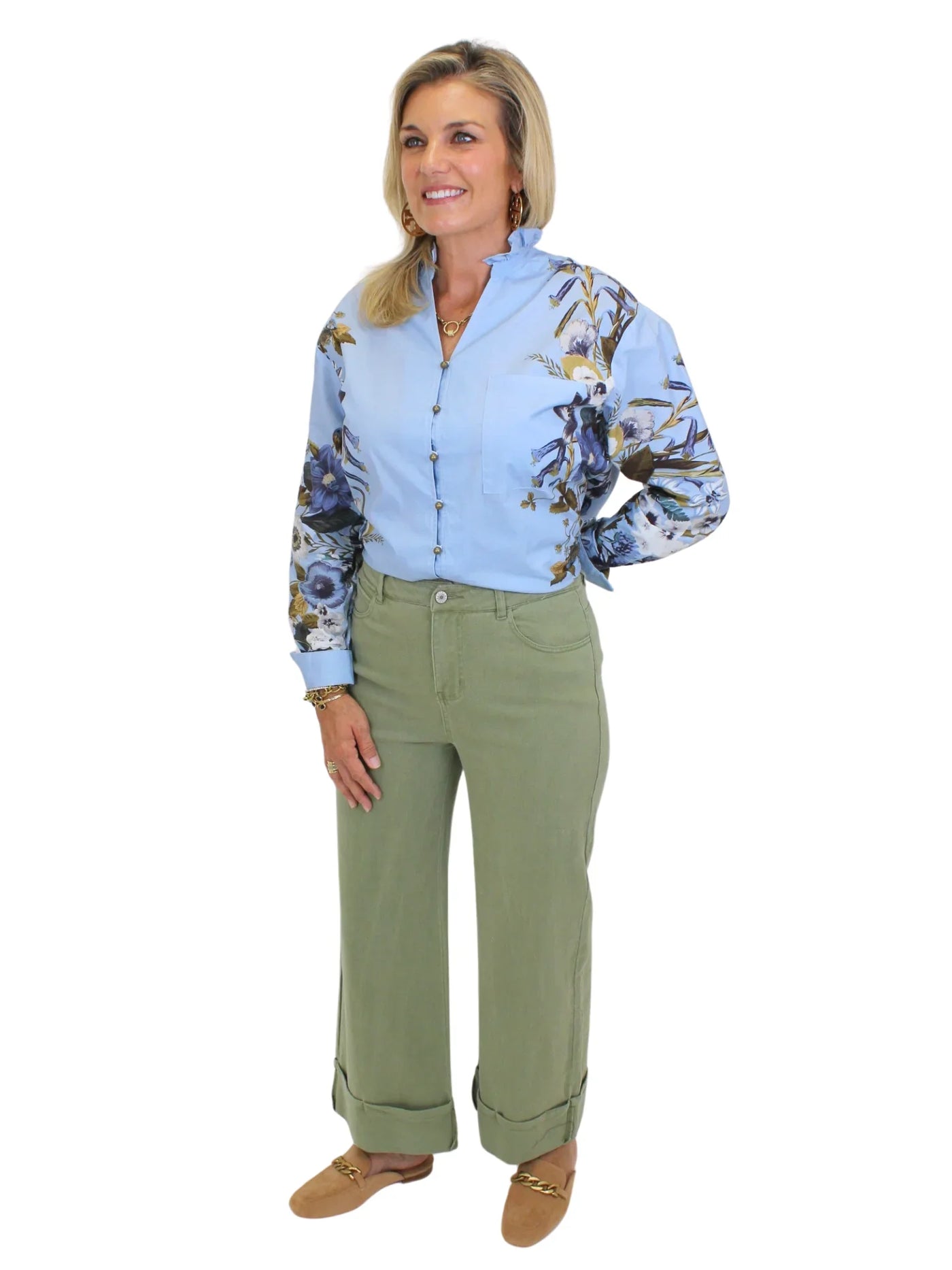 Model wearing blue blouse tucked into green wide leg cuffed jeans on white background, front.