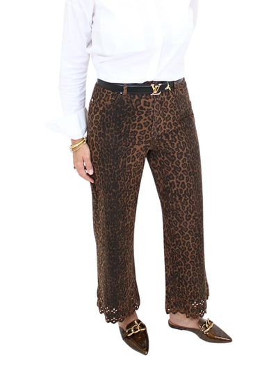 Woman wearing leopard print pants on a white background, closeup front.