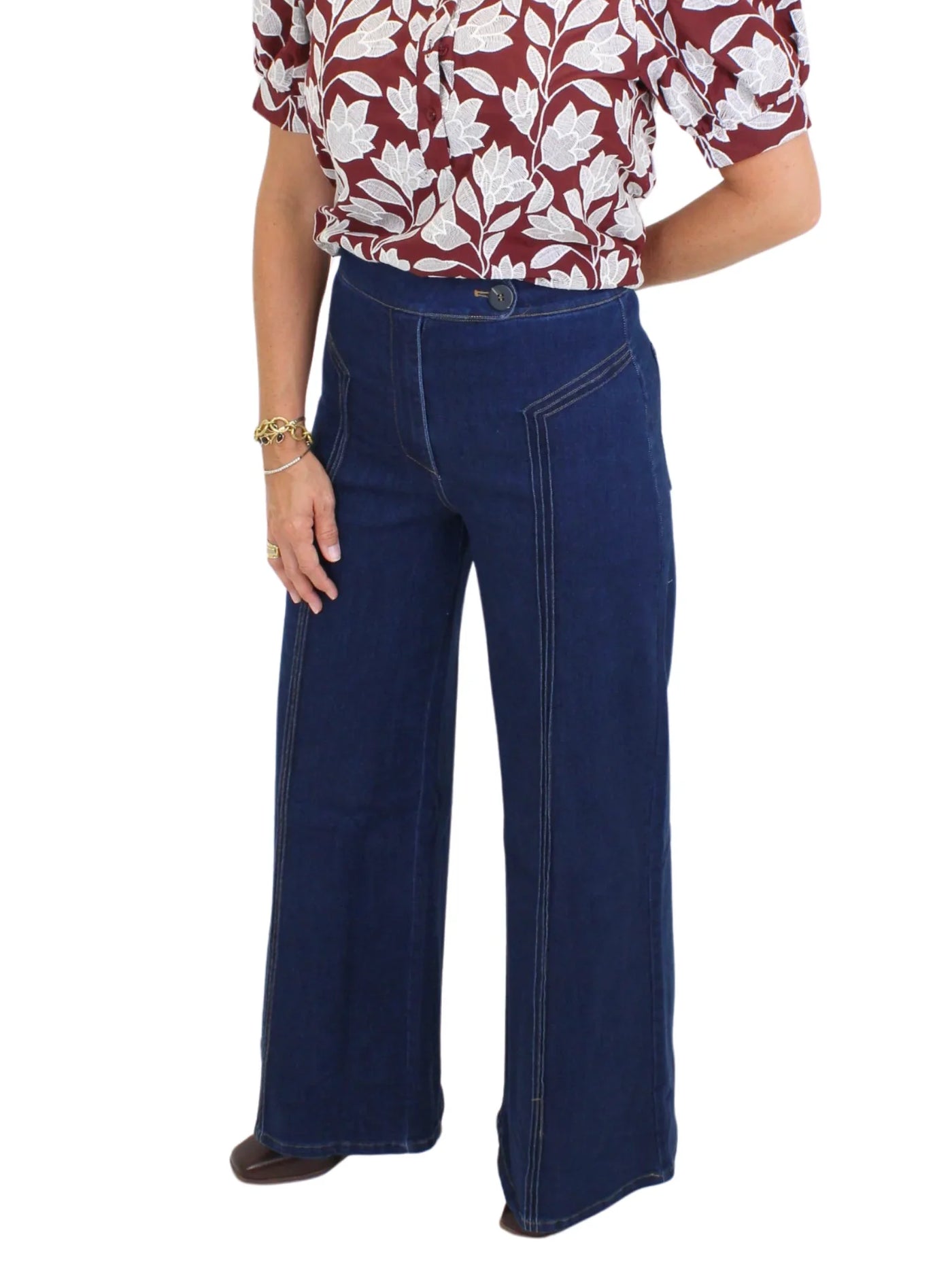 Model wearing dark wash wide leg jeans with front seam design on white background, closeup front.
