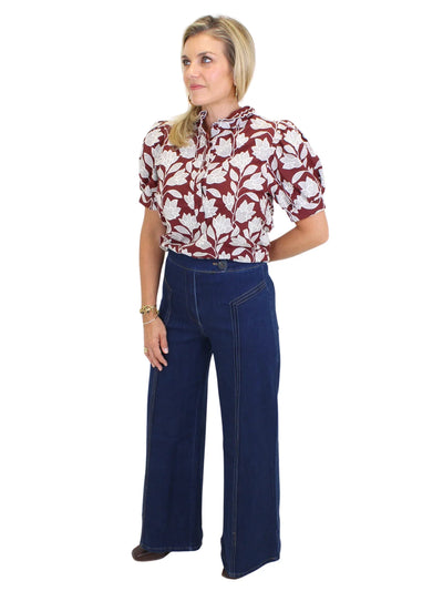 Model wearing dark wash wide leg jeans with front seam design on white background, front.