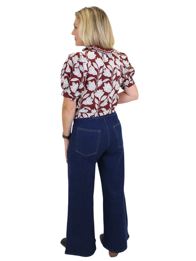 Model wearing dark wash wide leg jeans with front seam design on white background, back.