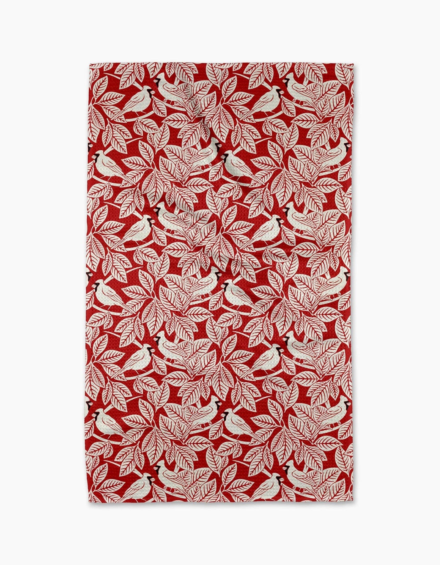 Red tea towel with white leaf and bird pattern on a white background