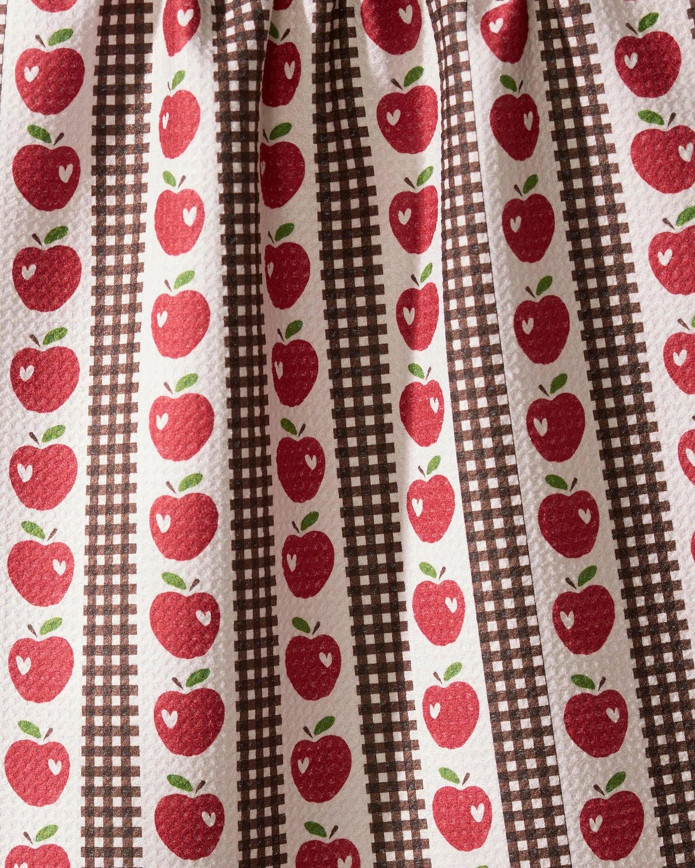 Fabric with red apple pattern on brown and white striped background