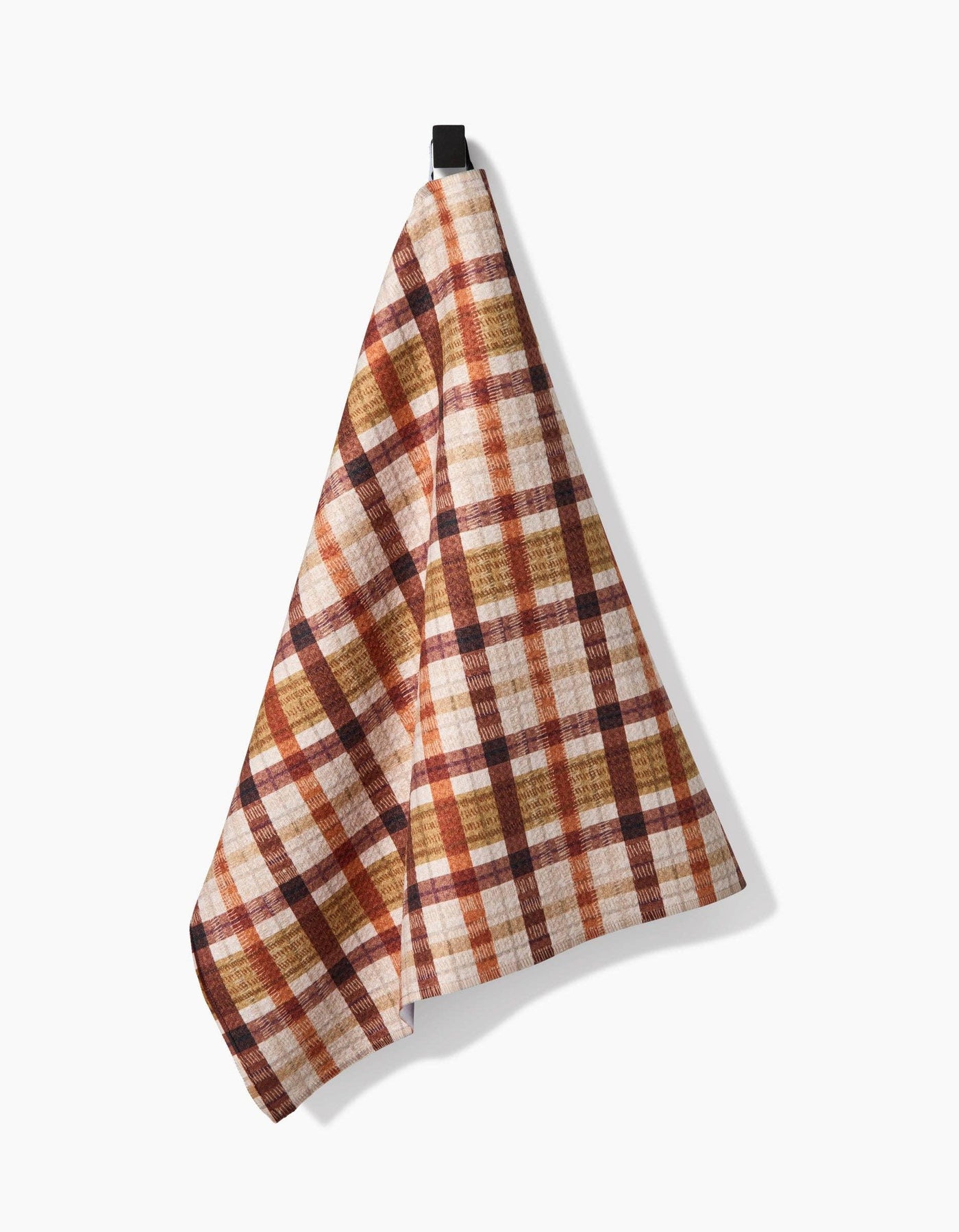 Plaid tea towel with brown and beige colors hanging on a white background