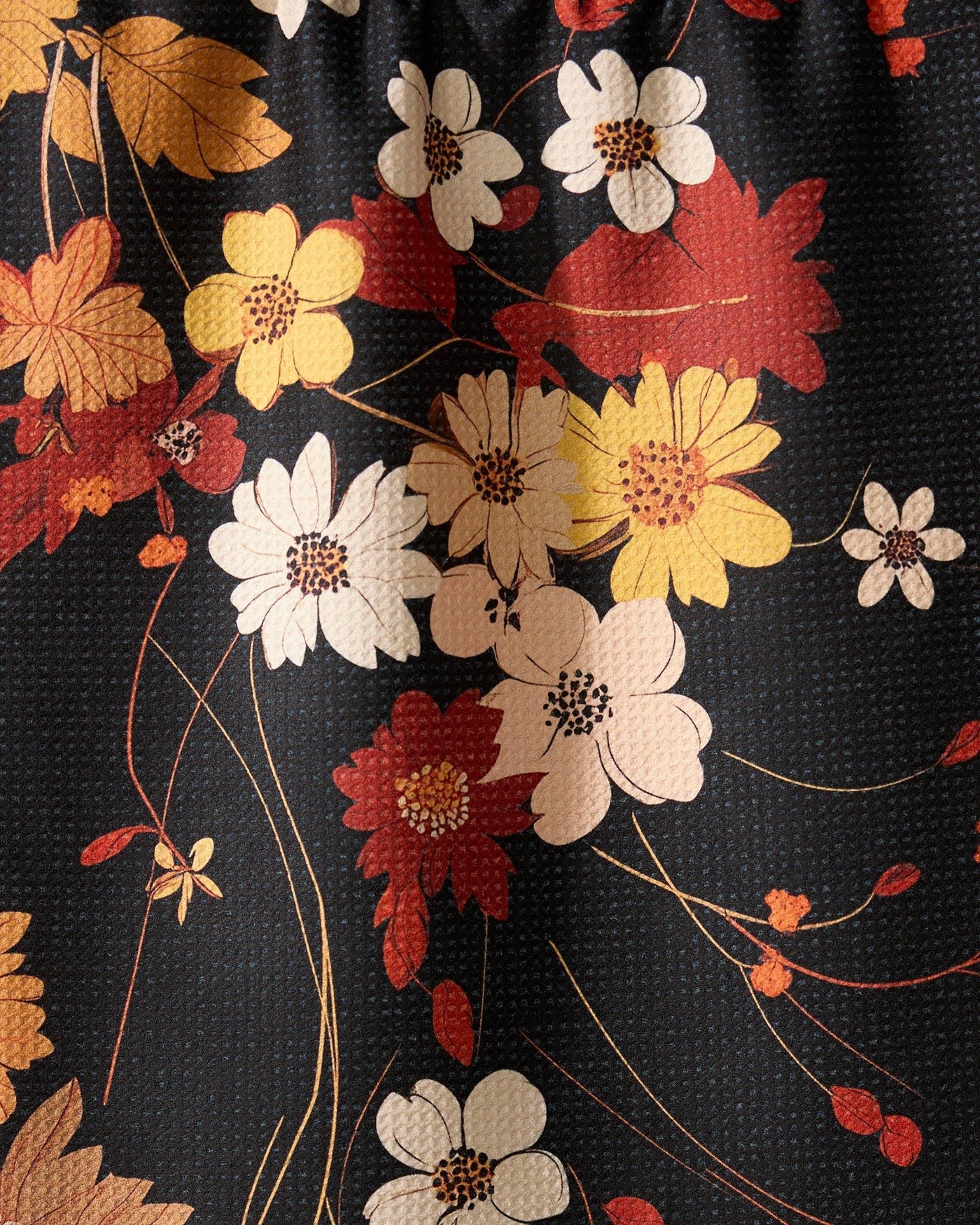 Black, red, and orange floral print tea towel closeup