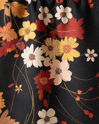Black, red, and orange floral print tea towel closeup