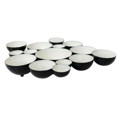 Set of black and white ceramic bowls arranged in a circular pattern on a white background