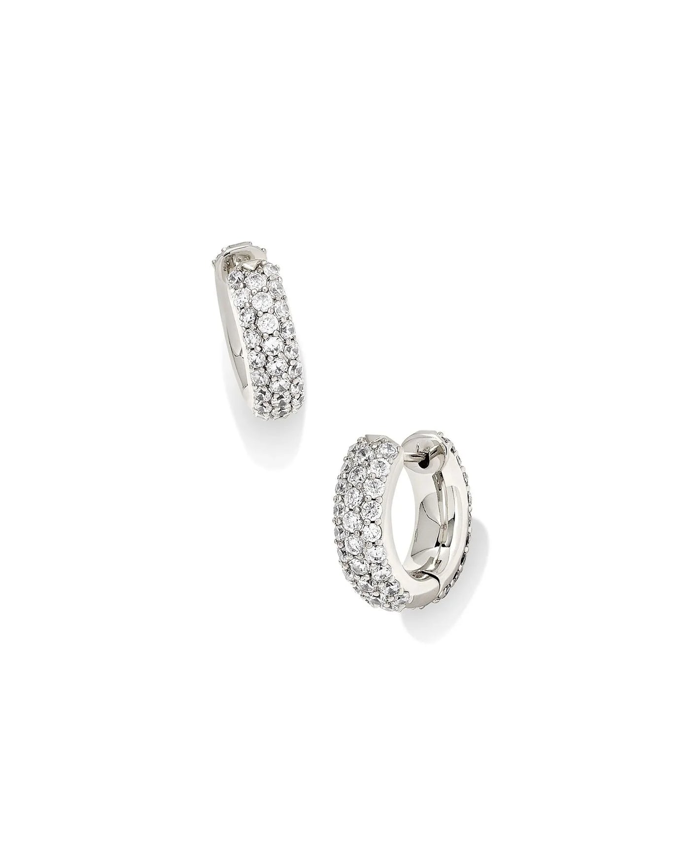 Pair of silver hoop earrings with clear stones on a white background.