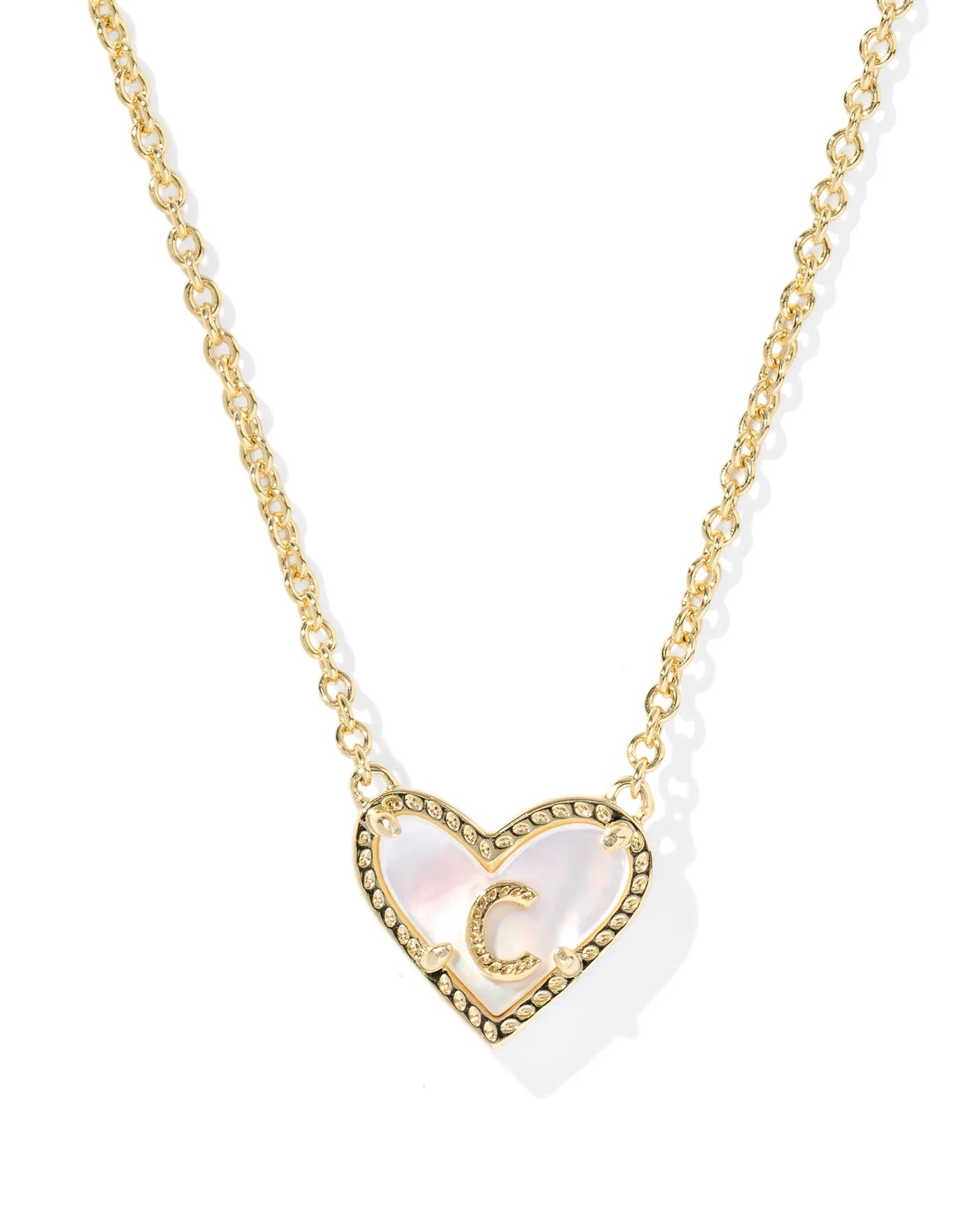 Gold necklace with a heart-shaped pendant and letter "C" on a white background.