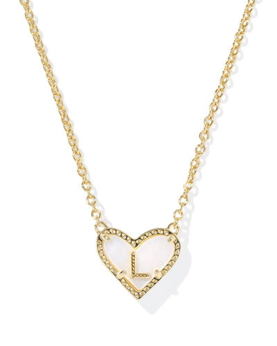 Gold necklace with heart-shaped pendant and letter "L" on white background.