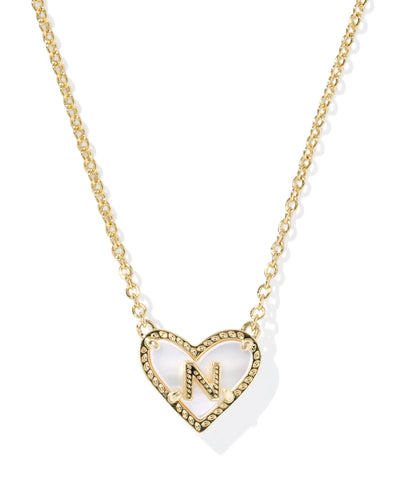 Gold necklace with heart-shaped pendant and letter "N" on white background.
