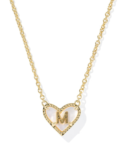 Gold necklace with a heart-shaped pendant featuring the letter 'M' on a white background.