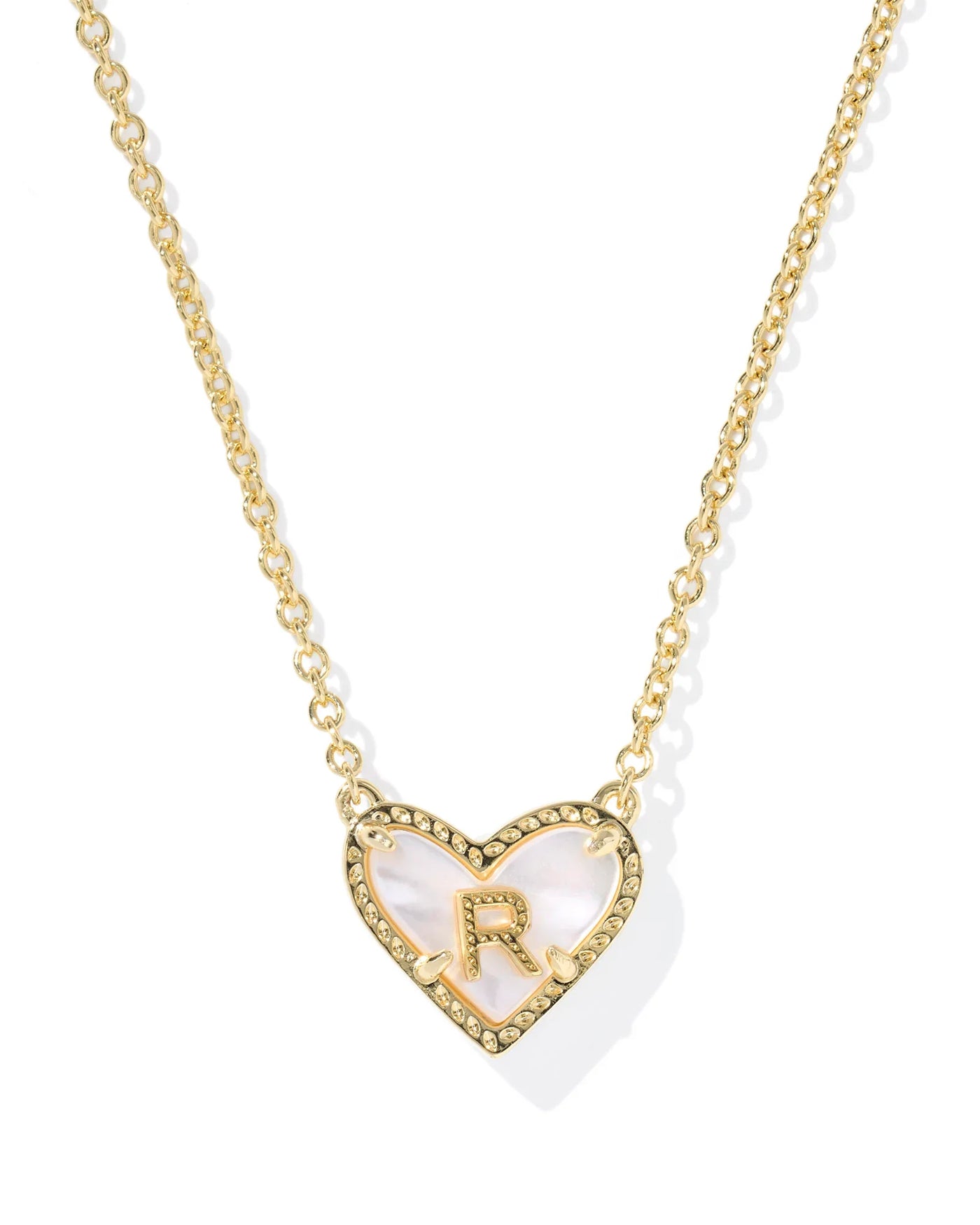 Gold necklace with a heart-shaped pendant featuring the letter 'R' on a white background.