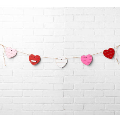 Hearts banner garland featuring white, red and pink hearts.  Hearts are connected on twine and can be strung on the wall for valentine's decor.