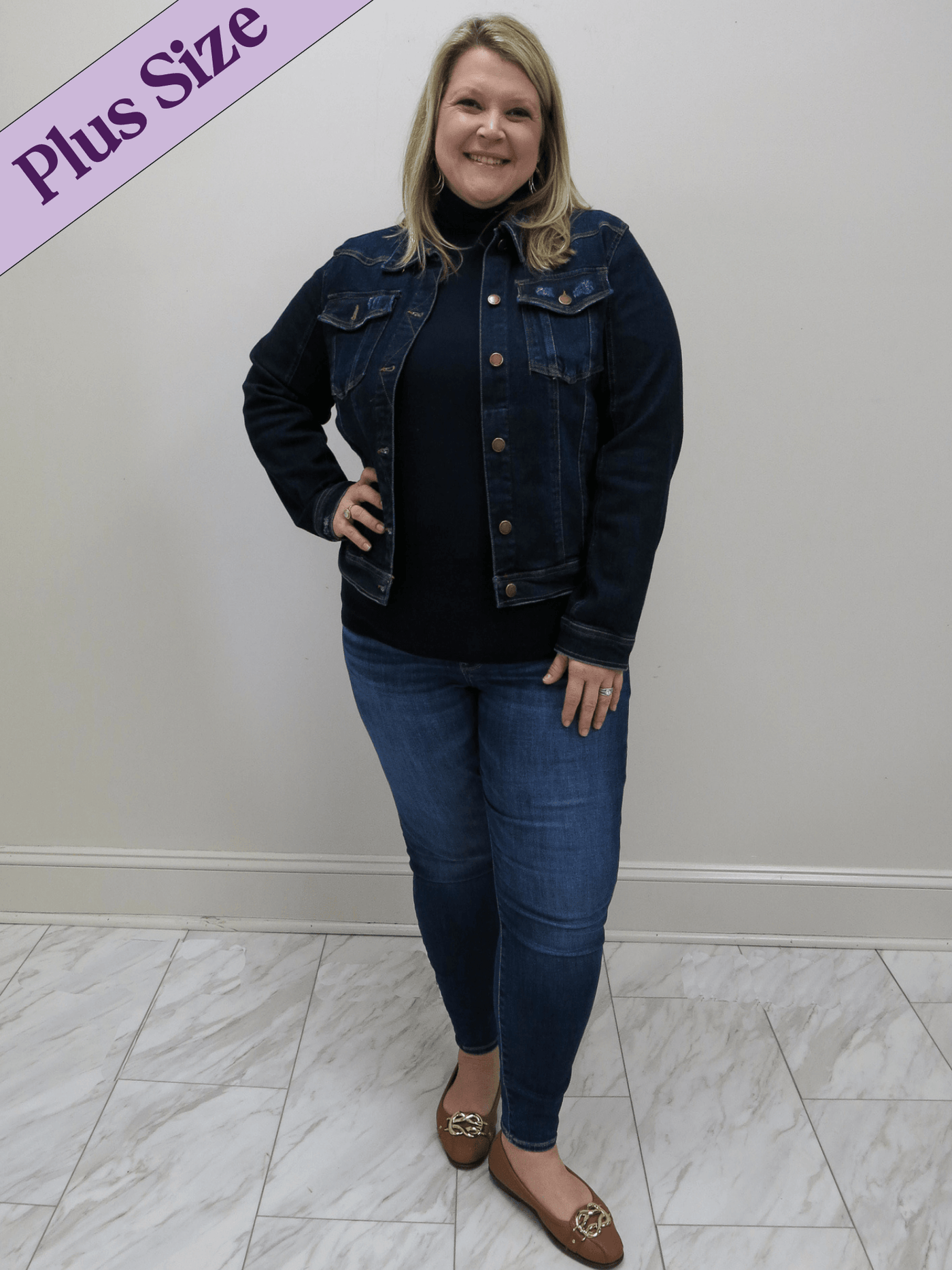 Risen plus size classic jean jacket with copper buttons with jeans and a navy turtleneck.