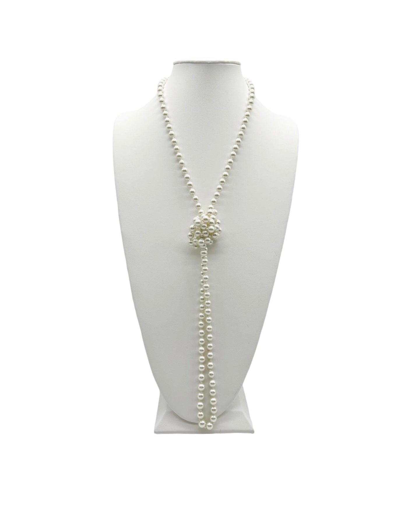 Long pearl necklace tied in a knock on a white neck display