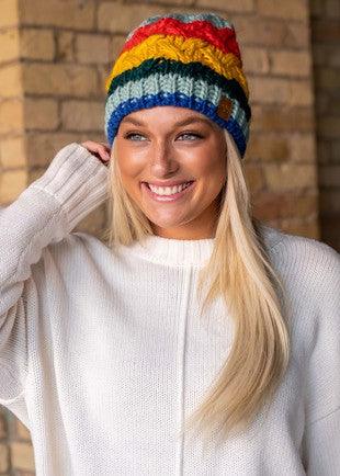 Multicolor striped cable knit beanie on model front view.