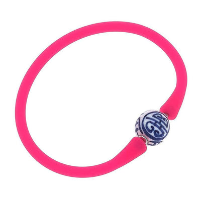 Neon pink silicone bracelet with a small chinoiserie bead