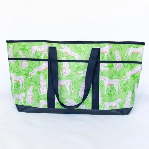 Large tote bag with green vinyl  with leaves and white leopards and peach spots and a navy base and handles