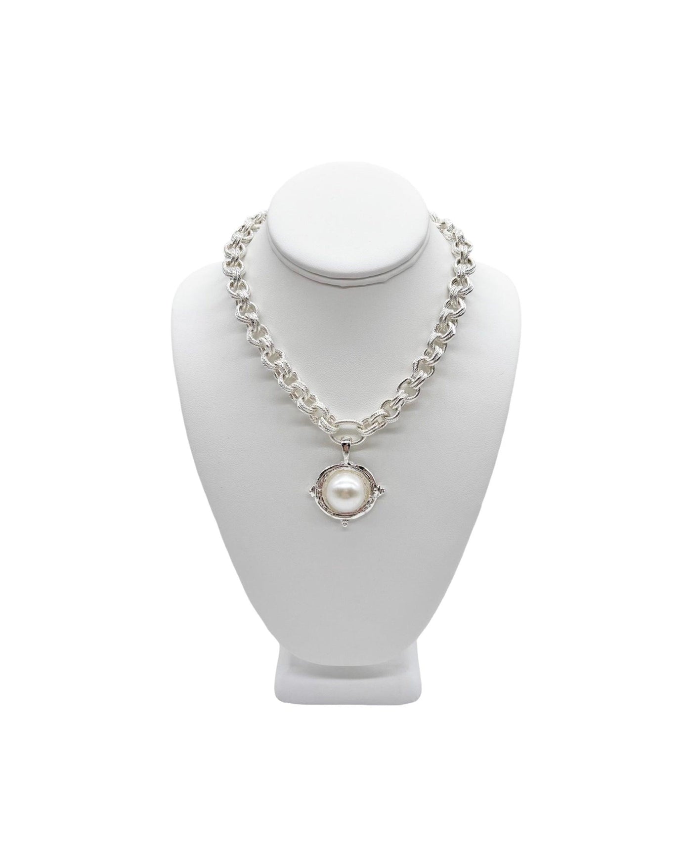 Double chainlink necklace with three studded silver drop pendant and accent pearl on a white display neck
